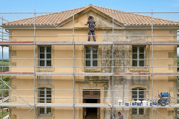 Artisan peintre réalisant l'application d'une peinture sur mur à Angoulême